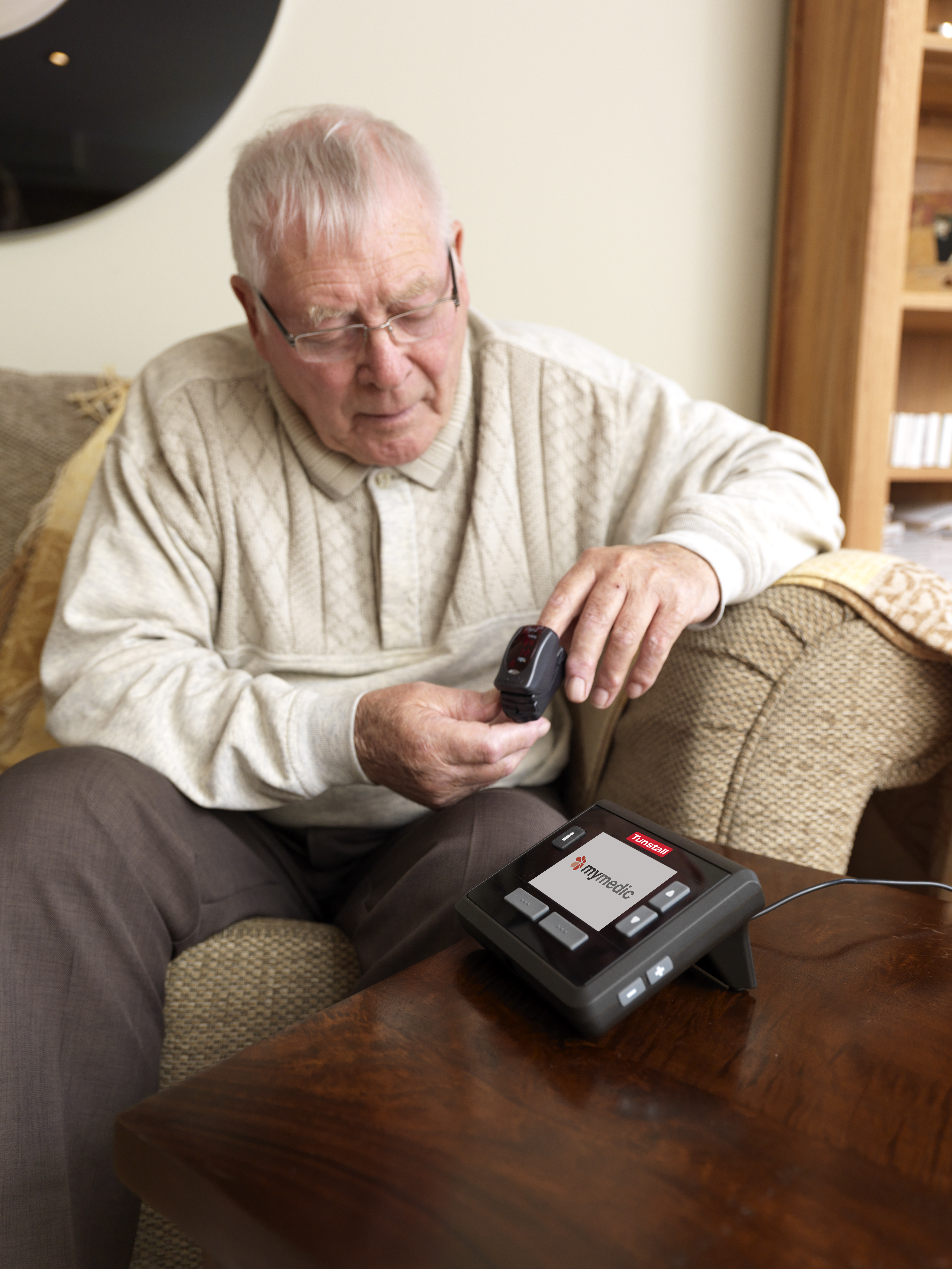 Elderly man using pulse oximeter